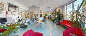 a lobby with plants and a red couch and tables at Surfside On The Lake in Lake George