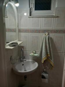 a small bathroom with a sink and a mirror at Lamia House in Lamía +15 photos