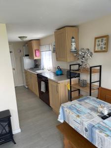 a kitchen with wooden cabinets and a counter top at Sheppey Village Ollie in Leysdown-on-Sea