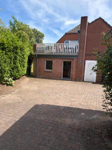 a brick house with a driveway in front of it at Modernes Landhaus Modern country house in Kalkar +3 photos