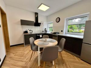 a kitchen and dining room with a table and chairs at Apartament Pod Wiatrakiem in Bęsia