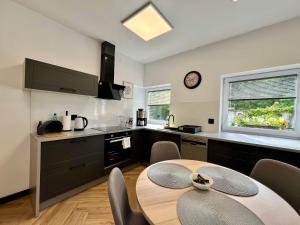 a kitchen with a table and a clock on the wall at Apartament Pod Wiatrakiem in Bęsia
