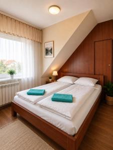 a bedroom with a large bed with two green pillows on it at Admiral aqua resort in Mielno +43 photos