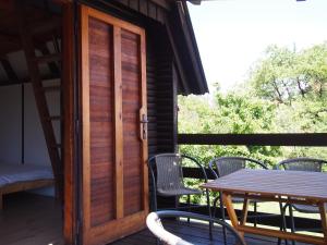 a wooden door on a deck with a table and chairs at Kemp Prachovská osma in Libuň
