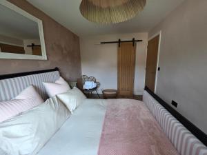 a bedroom with a bed with white sheets and a mirror at Olive & Ember - 1 Bed with private garden in Hythe