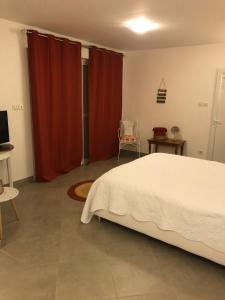 a bedroom with a bed and red curtains at Chamalobri in Labeaume