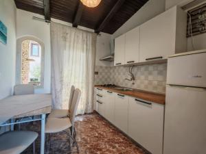 a kitchen with white cabinets and a table with chairs at Apartments Helena Pomer in Pomer