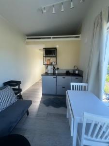 a living room with a table and a kitchen at Tiny house with lake view in Hammarö