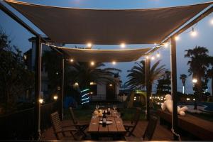 a patio with a table under a canopy at night at Jeju Its Hill Pension in Jeju