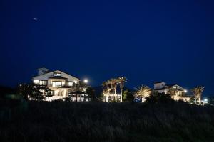 a large house on a hill at night at Jeju Its Hill Pension in Jeju