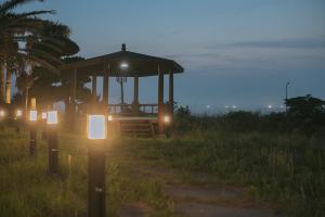 a gazebo with lights in a field at night at Jeju Its Hill Pension in Jeju