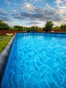 a large swimming pool with blue water at ForRest будинок з басейном та чаном in Moshchun +22 photos