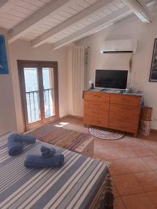 a bedroom with two beds and a dresser with a television at The Lake Chime in Colonno +7 photos