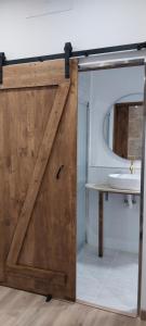 a sliding wooden door in a bathroom with a sink at O rincón do Mimo in Ribeira