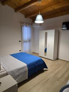 a bedroom with a blue bed and a white cabinet at Lemon House in Avola