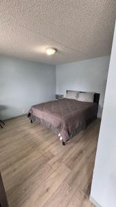 a bedroom with a bed and a wooden floor at Blue Mountain Motel in Okanogan