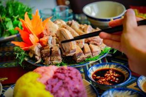 a person eating food on a table with plates of food at Moon Luxury Hotel in Hanoi