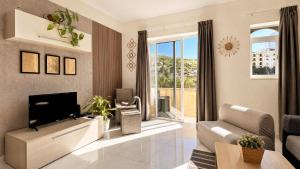a living room with a tv and a couch at Arzella Apartments Xlendi, Premium 2BR, Bus Stop & Market Opposite in Xlendi