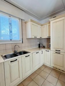 a kitchen with white cabinets and a sink at La casa di Teo in Cappella Maggiore