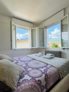 a bedroom with a large bed with windows at La casa di Teo in Cappella Maggiore