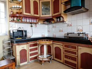 a kitchen with a stool in the middle of a kitchen at Nilayam guest house in Patna