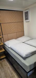 zwei Einzelbetten in einem Zimmer mit Holzboden in der Unterkunft Glamping L tiny , 2Ferienhäuser mit stillvolles Design und hohem Komfort Sauna Hot Tub in Platten