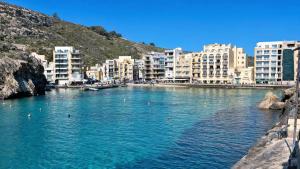 a river in a city with buildings in the background at Arzella Apartments Xlendi, Premium 2BR, Bus Stop & Market Opposite in Xlendi