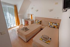 a small room with two beds and a window at Hotel Aia Kavatsi in Sozopol