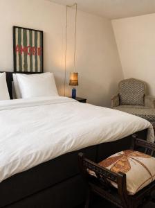 ein Schlafzimmer mit einem großen Bett und einem Stuhl in der Unterkunft La Rive in Enschede
