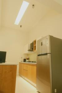a kitchen with a stainless steel refrigerator and wooden cabinets at Aura Stays L8 in Vagator