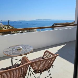 a table and chairs on a balcony with the ocean at Aura Sun Villa in Agios Romanos
