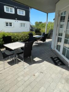eine Terrasse mit Tischen und Stühlen und ein Gebäude in der Unterkunft Bogense strand in Bogense