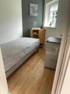 ein kleines Schlafzimmer mit einem Bett und einer Kommode in der Unterkunft Bogense strand in Bogense