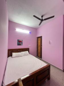 a bedroom with a bed with purple walls and a ceiling at Gravity Groups Core - Star residency in Pondicherry +17 photos
