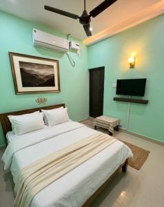a bedroom with a large bed and a flat screen tv at Gravity Groups Core - Star residency in Pondicherry