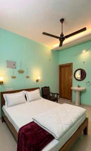 a bedroom with a large bed with a ceiling fan at Gravity Groups Core - Star residency in Pondicherry