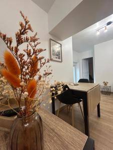 a vase with flowers on a table in a living room at Le refuge des coteaux in Trelou Sur Marne
