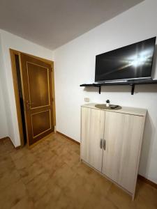 a room with a cabinet and a television on the wall at Castelsardo Homes in Castelsardo