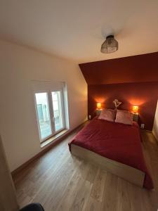 a bedroom with a red bed and a window at Le refuge des coteaux in Trelou Sur Marne