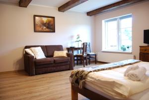 a bedroom with a bed and a couch and a table at Agroturystyka Pod Czaplami in Pieniężno