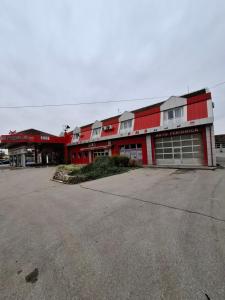 a red building with a parking lot in front of it at SOBE Svilajnac in Svilajnac