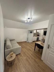a living room with a couch and a table at Le refuge des coteaux in Trelou Sur Marne +9 photos