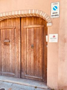 a pair of wooden doors on a building with a sign at Arega Rooms in Villasimius +7 photos