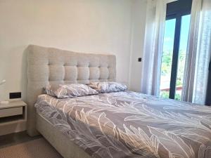 a bedroom with a large bed with a large window at Bananas in Kumbor