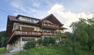 a house with a balcony with people on it at Ferienwohnungen Bauernhof Schilcher in Sankt Stefan im Lavanttal