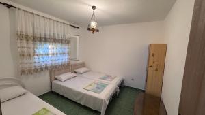 a bedroom with two beds and a chandelier at Private guest-house Gutic in Sutomore