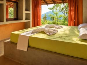 a bed sitting in a room with a window at Bathle Eco Resort in Mawanella
