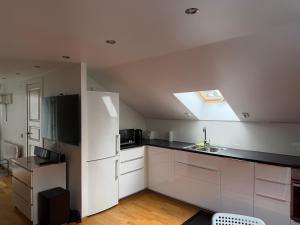 a kitchen with white cabinets and a skylight at Studio i Nykvarn in Nykvarn +4 photos