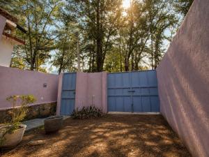 a fence with a blue garage door in a yard at Suite Privada Nueva Boutique con Entrada Independiente y Acceso Autónomo, A 5 Min del Centro in Pátzcuaro +18 photos