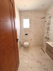 a bathroom with a toilet and a window at Corail in Djerba +11 photos